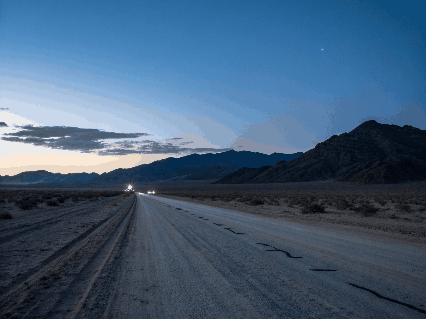 Open road horizon at dusk with a warm garage-lit glow